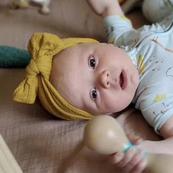 Baby with Wooden Rattle