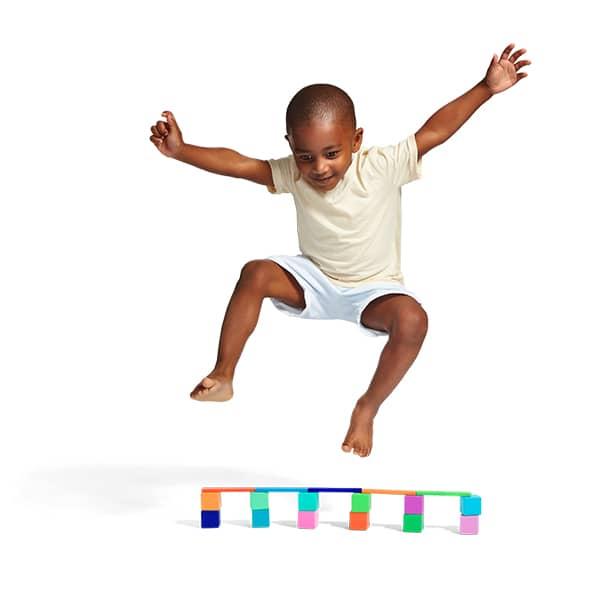 Child jumping over blocks image